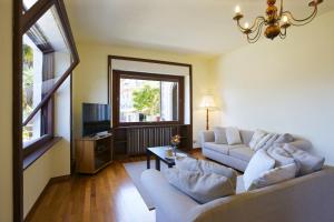 un soggiorno con 2 divani bianchi e una finestra di Casa Vista Isole Borromee a Stresa