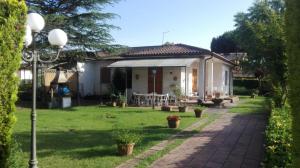 een huis met een tuin en een stenen oprit bij La casa di Angelo e Gladys in Bella Farnia