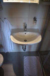 een witte wastafel in een badkamer met een handdoek bij Pension Weinberg in Mörbisch am See