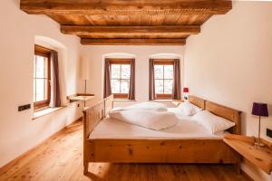 a bedroom with a large wooden bed with windows at Josephus in Senales