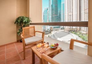 balcón con mesa, sillas y vistas a la ciudad en Luxury Casa - Elite Marina 1 Bedroom Apartment - JBR Beach en Dubái