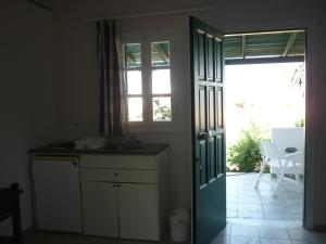 a kitchen with a door leading to a patio at Manolis Farm Guest House in Aliko Beach