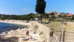 um grupo de pessoas numa praia perto da água em Dea Apartments em Pula