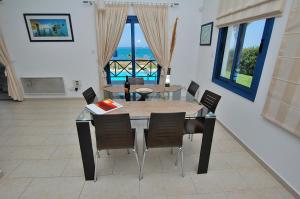 comedor con mesa y sillas con vistas en Kymmates Beach Front Villas en Pafos