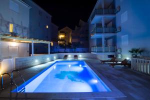 una piscina di notte accanto a un edificio di Apartments Sara a Bol