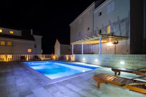 una piscina di fronte a un edificio di notte di Apartments Sara a Bol