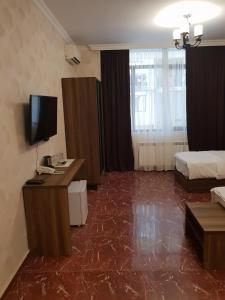 a room with a television and a bed in it at Ire Palace in Batumi