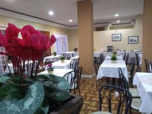 a dining room with white tables and chairs at Hotel Platanus in Campos do Jordão