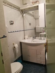 a bathroom with a white sink and a toilet at Apartman Paula in Biograd na Moru