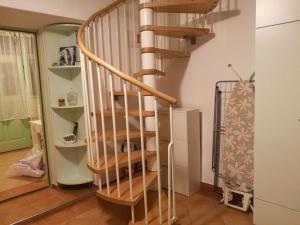 a wooden spiral staircase in a living room at Apartman Paula in Biograd na Moru