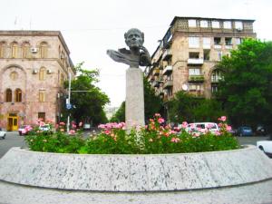 a statue in the middle of a street with flowers at Hostel Sakharov & Tours in Yerevan