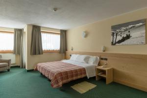 Pokój hotelowy z łóżkiem i krzesłem w obiekcie Hotel Nordik w mieście Santa Caterina Valfurva