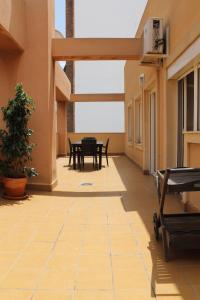 eine Terrasse mit einem Tisch und Stühlen in einem Gebäude in der Unterkunft Atico centro Alicante in Alicante