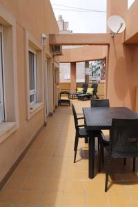 einen Balkon mit Tischen und Stühlen in einem Gebäude in der Unterkunft Atico centro Alicante in Alicante