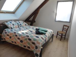 a bedroom with a bed and a chair in a attic at La maison de Julien et Marie-Louise in Objat