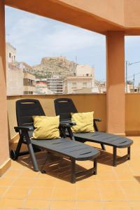 2 Stühle und ein Tisch auf dem Balkon in der Unterkunft Atico centro Alicante in Alicante