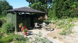 einen grünen Pavillon mit einem Tisch und Stühlen im Garten in der Unterkunft Nad stawem in Biała Olecka