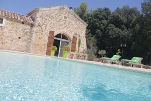 una piscina frente a un edificio de piedra en Le Mas De La Seuve, en Richerenches