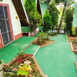 a garden with green paint on the walkway at Chales Alpes Germanicos in Monte Verde