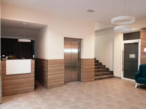 GračanicaにあるHotel SAX Gračanicaの階段と青い椅子のあるロビー