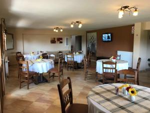a dining room with white tables and chairs and a tv at Guesthouse Alkioni in Lithótopos