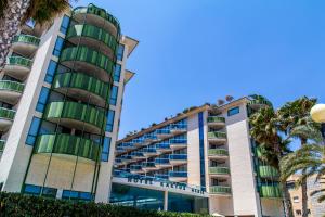a building with palm trees in front of it at KAKTUS Hotel Kaktus Albir in Albir