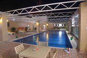 a large swimming pool with a table in a building at Park Regis Lotus Hotel in Manama