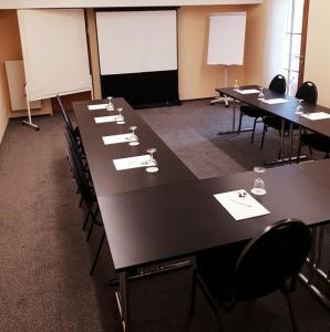 une salle de conférence avec de longues tables et chaises dans l'établissement Eurostar Hotel, à Castrop-Rauxel