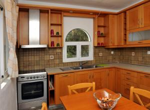 a kitchen with wooden cabinets and a wooden table at Nina Areti in Skiathos +11 photos