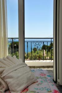 a bedroom with a view of the ocean from a balcony at Nina Areti in Skiathos