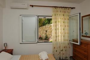 a bedroom with a bed and a window at Nina Areti in Skiathos
