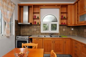 a kitchen with wooden cabinets and a table and a window at Nina Areti in Skiathos
