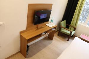 a room with a desk with a television and a chair at The Three Oaks Boutique Hotel in Mussoorie
