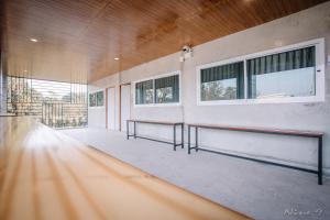 une pièce vide avec deux bancs dans un bâtiment dans l'établissement The Day Home Hotel, à Pak Chong