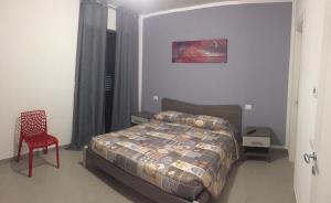 a bedroom with a bed and a red chair at B&B Casa Giorgia in Campobasso