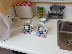 トーキーにあるSelf Contained Rooms in Central Torquayの洗面台の横のカウンターに座ったコーヒーカップ2杯