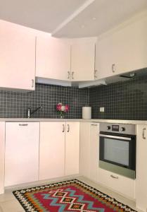 a kitchen with white cabinets and a rug on the floor at Hinna Garden in Stavanger