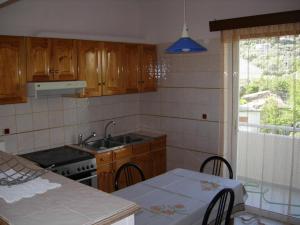 uma cozinha com um lavatório e uma mesa com cadeiras em B1 Apt Mytilini em Mitilene