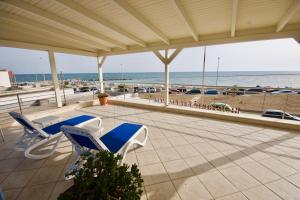 Hotel Teti في توري موتسا: شرفة مع كراسي وإطلالة على الشاطئ