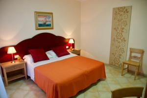 una camera da letto con un letto grande con una coperta arancione di Hotel Teti a Torre Mozza