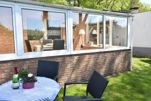 a patio with a table and chairs and a glass house at Haus Seepferdchen in Graal-Müritz