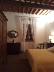 a bedroom with a bed and a mirror and a window at Torre rossa in Bolgheri