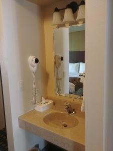 a bathroom with a sink and a mirror at Boarders Inn & Suites by Cobblestone Hotels - Broken Bow in Broken Bow