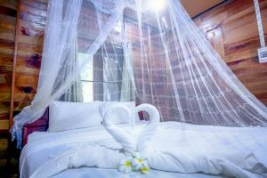 a bedroom with a bed with a mosquito net at Khao Sok Palmview Resort in Khao Sok