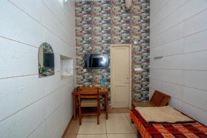 um pequeno quarto com uma mesa e uma televisão na parede em National Guest House em Jalandhar