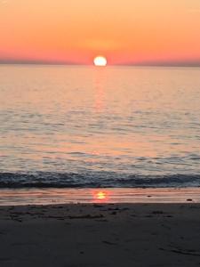 a sunset on the beach with the sun setting at Camping Barataud in Saint-Denis-dʼOléron