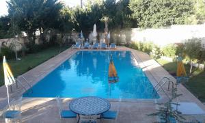 a large swimming pool with a table and chairs at Villa Pomme d'Or in Midelt
