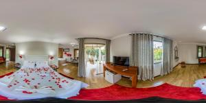 a bedroom with a bed with red flowers on it at Pousada Valle das Colinas in Tiradentes +74 photos