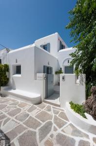 a white villa with a stone patio in front of it at Villa Memories in Prodromos Paros