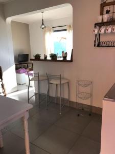 a living room with a table and chairs and a window at Chalé Serra do Luar in Santo Antônio do Pinhal